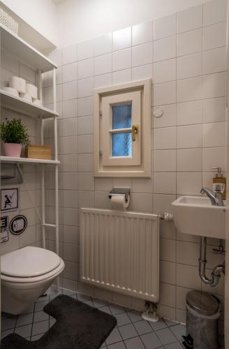 a bathroom with a toilet and a sink and a window at SISHAUS - Private Room Rental in Salzburg