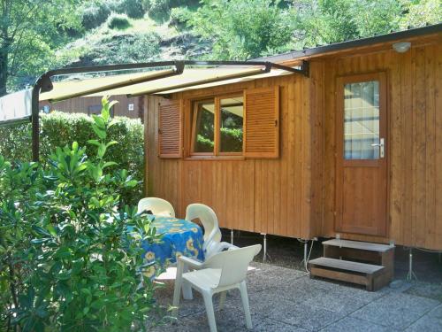 a wooden cabin with a table and chairs in front of it at Villaggio Camping Valdeiva in Deiva Marina