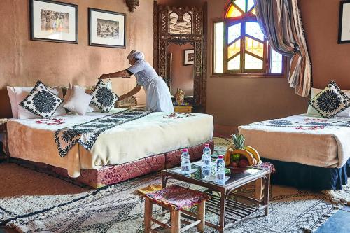 a man standing on two beds in a room at Riad Ouarzazate in Ouarzazate