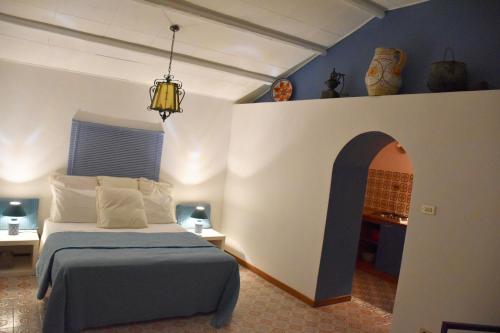 a bedroom with a bed and an archway at Villa Martius in San Pier Niceto