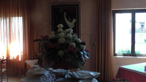 a vase of flowers sitting on top of a table at Hotel Galles in Paluzza