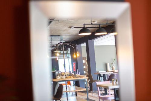 a view of a dining room with tables and chairs at Carré Pau Airport Hôtel in Serres-Castet