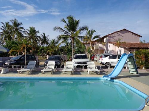 una piscina con un tobogán en un aparcamiento en Residencial Bahia Sol, en Nova Viçosa
