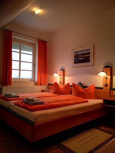 a bedroom with a large bed with orange pillows at Golfcentrum Schloss Karnitz Rügen in Garz