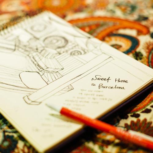 a sketch of a house with a pencil on a table at Rocket Hostels Gracia in Barcelona