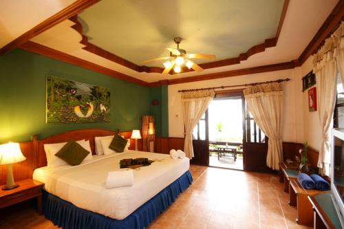- une chambre avec un lit et un ventilateur de plafond dans l'établissement Salad Beach Resort - SHA Extra Plus, à Salad Beach
