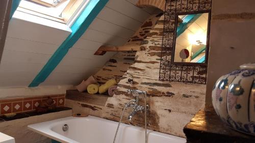 a bathroom with a bath tub and a window at Le Petit Logis De Tinténiac in Angers