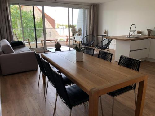 le vergoyer في كاليه: غرفة معيشة مع طاولة وكراسي خشبية