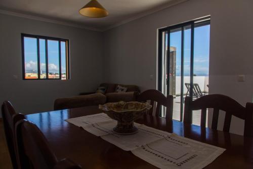 a dining room with a table with a vase on it at Arquinha Apartment in Ponta Delgada