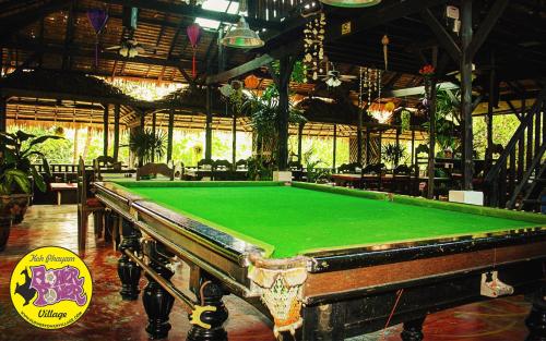 a pool table in a large room with a pool table at Flower Power Farm Village in Ko Phayam