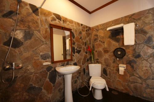 a bathroom with a toilet a sink and a mirror at Salad Beach Resort - SHA Extra Plus in Salad Beach