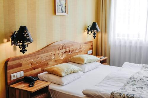 a bedroom with two beds and two lamps and a phone at Bajka Hotel & Resort in Grodziec