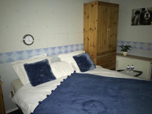 1 dormitorio con 1 cama con almohadas azules y blancas en La Nuova Casa del Campo (vh De Kamp), en Dinxperlo