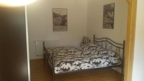 ライプツィヒにあるFerienwohnung mit Fitnessのベッドルーム1室(ベッド1台付)が備わります。壁に2枚の写真が飾られています。