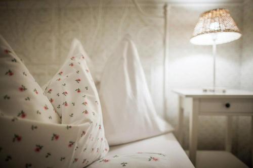 a room with a bed with pillows and a lamp at Huber Vendégszobák in Fertőrákos