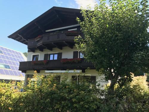 a white building with a black roof and trees at Haus Pankratz in Kitzbühel