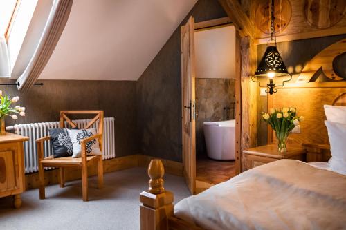 a bedroom with a bed and a bathroom at Bajka Hotel & Resort in Grodziec