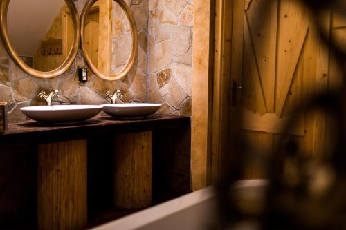 a bathroom with two sinks and two mirrors at Bajka Hotel & Resort in Grodziec