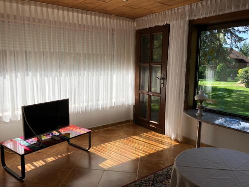 a living room with a tv and a window at Ferienhaus Annerose in Wendisch Rietz