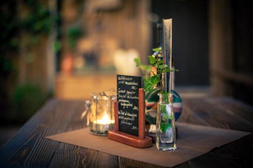 a table with a candle and a vase with a plant at Huber Vendégszobák in Fertőrákos