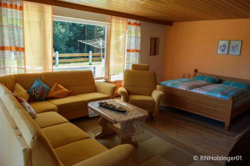 - un salon avec des canapés, un canapé et une table dans l'établissement Ferienwohnung Holzinger, à Hauzenberg