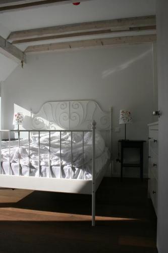 a white bed in a bedroom with a white wall at Lijo in Gargždai