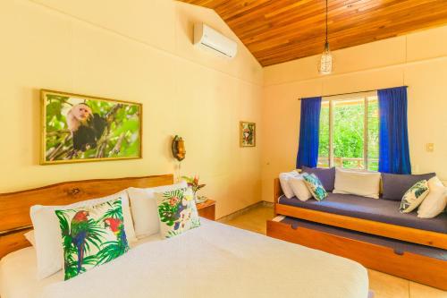 a bedroom with two beds and a couch at Hotel El Mono Feliz in Ojochal