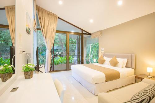 um quarto com uma cama grande e um sofá em Arantarakiri Resort Khao Yai em Mu Si