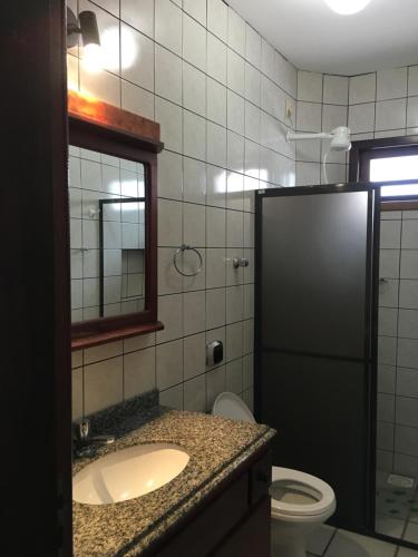 a bathroom with a sink and a toilet and a mirror at Excelente Casa em Bombas in Bombinhas