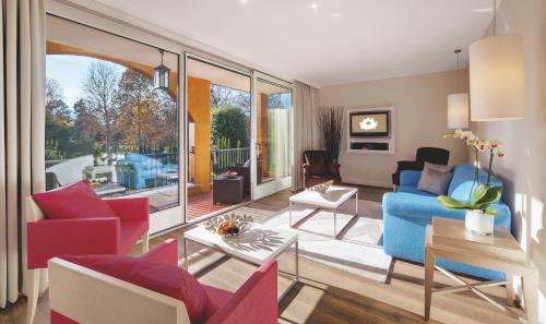 a living room with colorful furniture and a large window at Giardino Ascona in Ascona