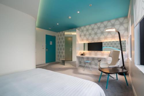 a bedroom with a bed and a desk and a table at Park Inn by Radisson Amsterdam City West in Amsterdam