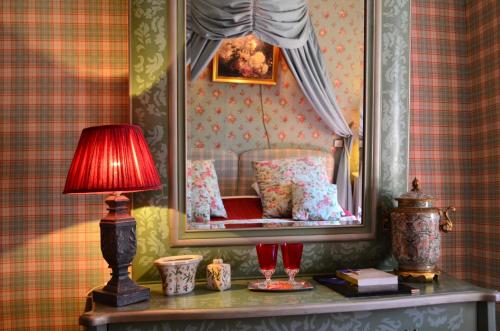 a bedroom with a bed with a mirror on the wall at Hotel Le Saint Laurent in Saint-Laurent-des-Arbres