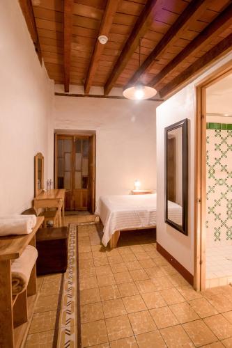 a bedroom with a bed and a table in a room at Hotel Meson Cuevano in Guanajuato