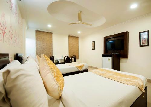 um quarto de hotel com duas camas e uma televisão em HOTEL DAKHA INTERNATIONAL - Karol Bagh, New Delhi em Nova Deli