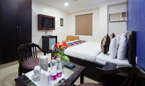 a hotel room with a bed and a table with flowers at HOTEL DAKHA INTERNATIONAL - Karol Bagh, New Delhi in New Delhi