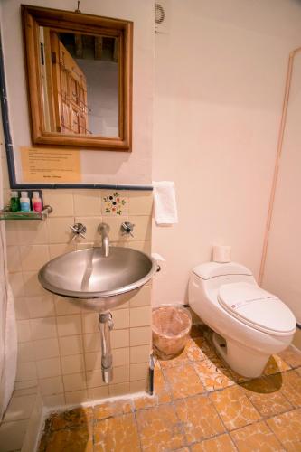 a bathroom with a sink and a toilet at Hotel Meson Cuevano in Guanajuato