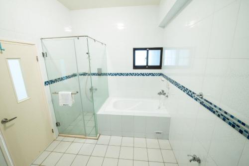 a white bathroom with a shower and a tub at Travel Friends in Huxi