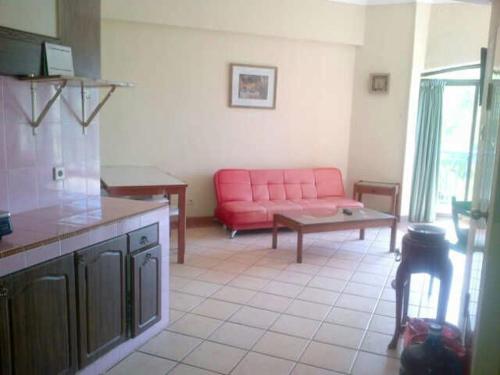 a living room with a red couch and a table at New Renovated 2 Rooms Luxury Suites Anyer in Anyer