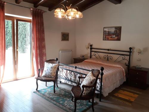 um quarto com uma cama, 2 cadeiras e uma janela em La Camelia B&B em Velletri