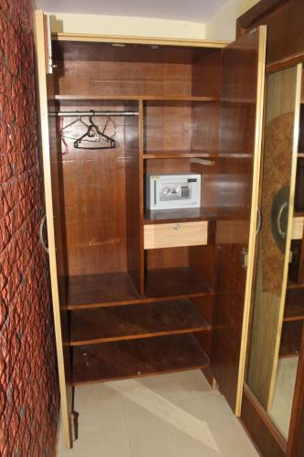a kitchen with wooden shelves and a microwave at Mama Mids Home in Morjim