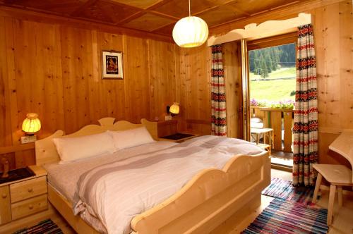 a bedroom with a bed in a room with wooden walls at Villa Insam Apartment in Selva di Val Gardena