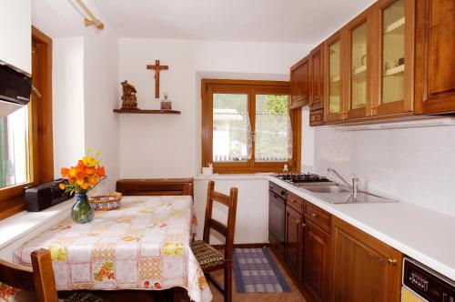 une cuisine avec une table et un vase de fleurs. dans l'établissement Villa Insam Apartment, à Selva di Val Gardena