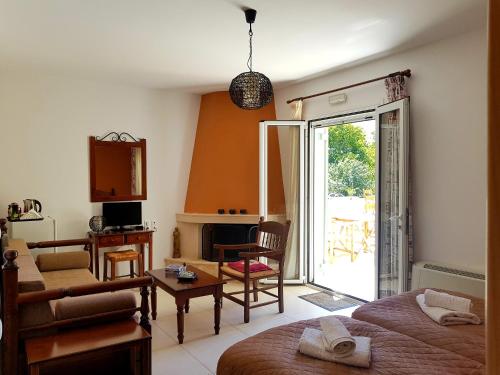 a living room with a bed and a living room with a fireplace at Maison Kronio Lassithi Plateau in Marmakéton