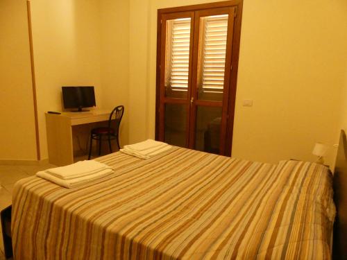 a bedroom with a bed with two towels on it at BEB 2000 in Sassari