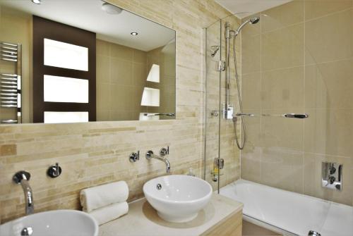 a bathroom with two sinks and a shower and a tub at Spacious 2-Bedroom Apartment with Parking in Windsor 4LA by Accommodation Windsor in Windsor