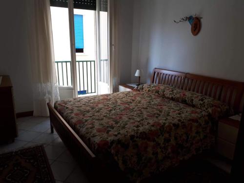 een slaapkamer met een bed met een bloemenspread erop bij appartamento vicino al mare Alassio in Alassio