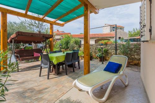 a patio with a table and chairs and a pergola at Apartment Macan in Bale