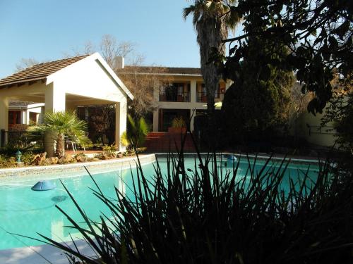 una casa con piscina frente a una casa en 2 Leafed Doors en Johannesburgo