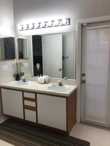 a bathroom with two sinks and a large mirror at Pool Home 15 Minutes From Disney in Davenport