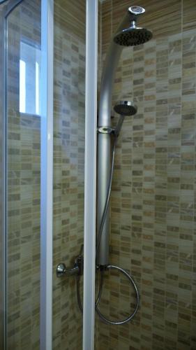 a shower with a shower head in a bathroom at La Mia Casa Vendégház in Kaposvár
